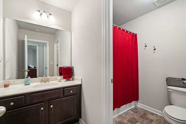9475 Dunmoore Dr, Cumming, GA 30028 - full bath featuring visible vents, baseboards, toilet, stone finish floor, and vanity