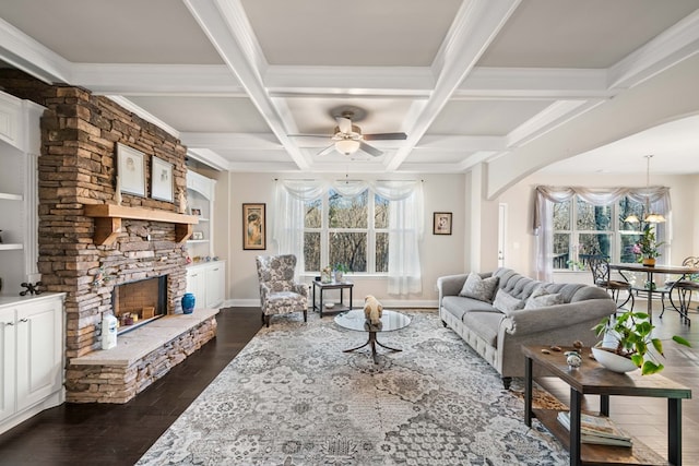 living area featuring a stone fireplace, plenty of natural light, dark wood finished floors, and arched walkways