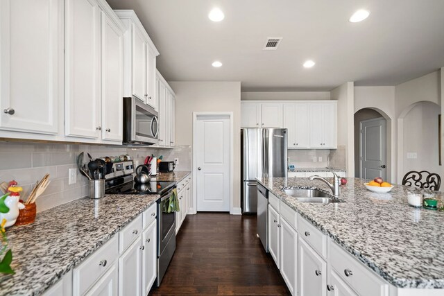 9475 Dunmoore Dr, Cumming, GA 30028 - kitchen featuring visible vents, a sink, appliances with stainless steel finishes, white cabinets, and dark wood-style flooring