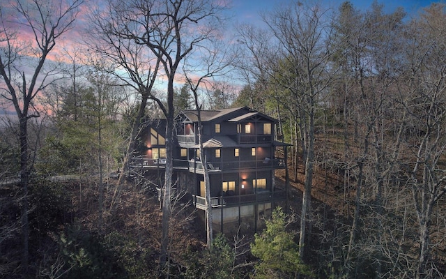 back house at dusk featuring a balcony