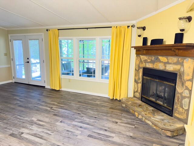 unfurnished living room with wood-type flooring, a fireplace, crown molding, and french doors