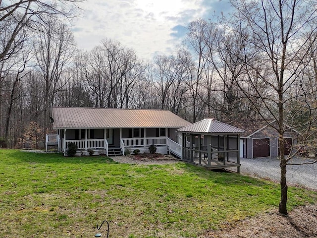 view of front of house with a front lawn, a garage, and an outbuilding