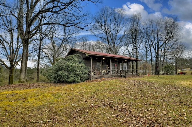 chalet / cabin featuring a porch, metal roof, and a front lawn