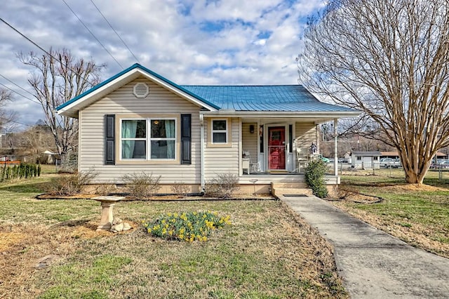 view of front of house featuring metal roof, a front lawn, and a porch