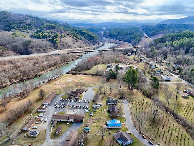 aerial view featuring a wooded view and a water and mountain view