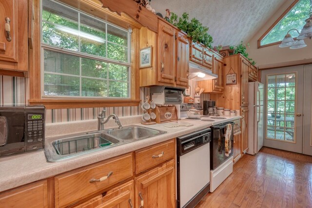 kitchen featuring light wood-type flooring, sink, white appliances, and lofted ceiling