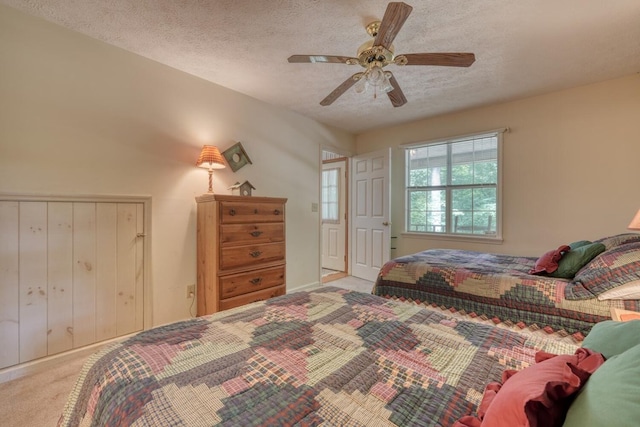 bedroom featuring a textured ceiling, carpet floors, and ceiling fan