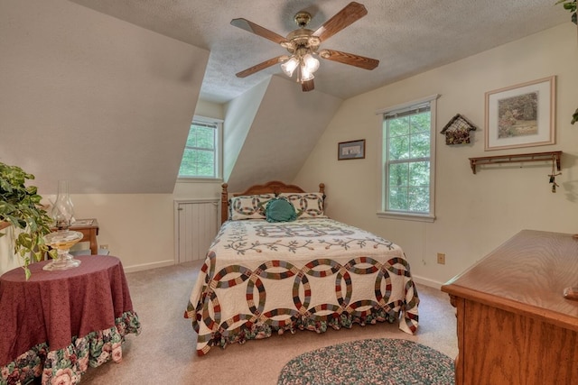 bedroom with ceiling fan, a textured ceiling, lofted ceiling, and light colored carpet