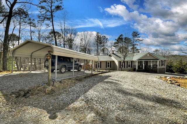 view of front facade with metal roof, a carport, and driveway