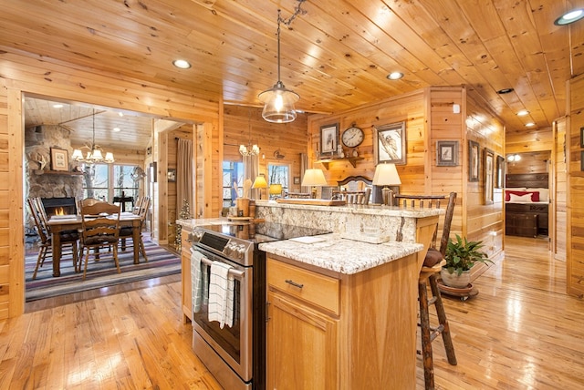 226 Shepherds Walk, Morganton, GA 30560 - kitchen with a notable chandelier, a breakfast bar area, stainless steel electric range oven, wooden walls, and open floor plan