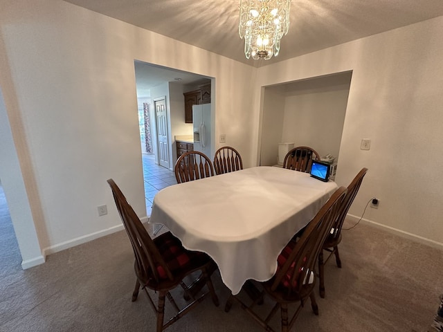 dining room featuring a notable chandelier and carpet