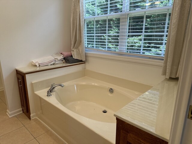 bathroom featuring tile patterned flooring, tiled bath, and a wealth of natural light