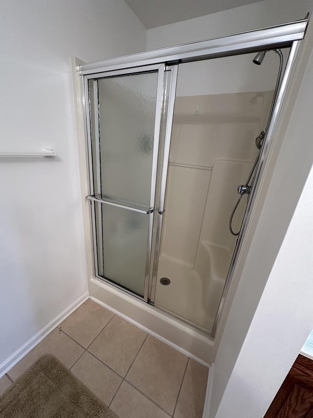 bathroom featuring a shower with door and tile patterned flooring