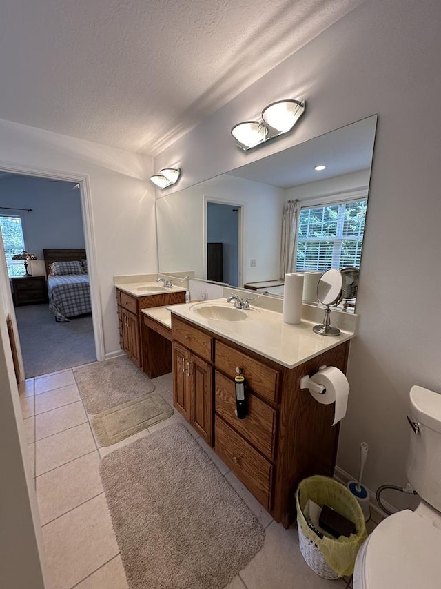 bathroom featuring vanity, tile patterned floors, a textured ceiling, and toilet