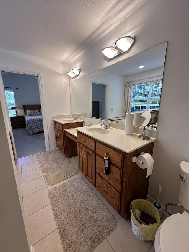 bathroom featuring vanity, tile patterned floors, a textured ceiling, and toilet