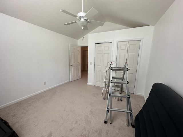 workout room with lofted ceiling, light colored carpet, and ceiling fan