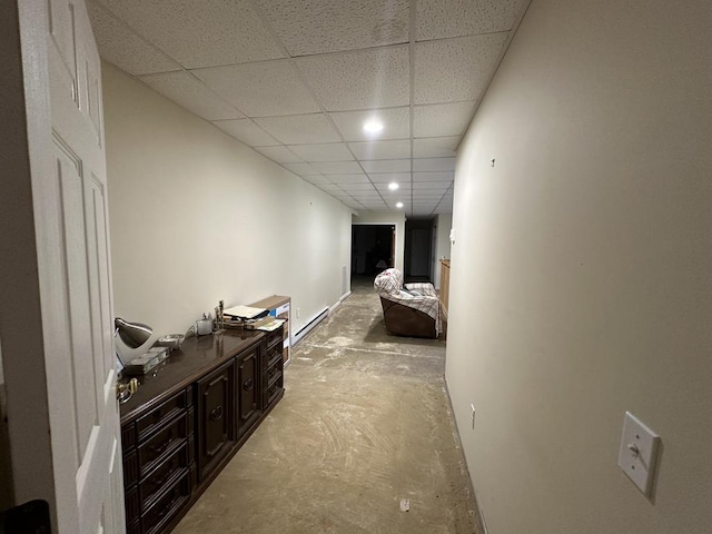 corridor featuring a baseboard heating unit and a paneled ceiling