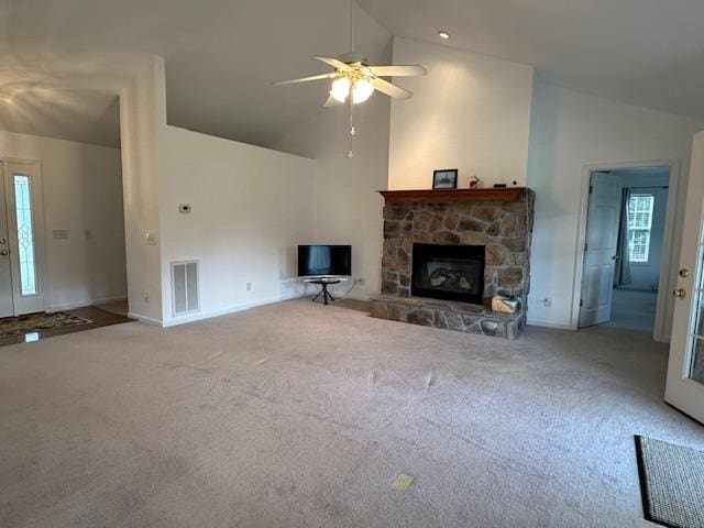 unfurnished living room with a stone fireplace, carpet, high vaulted ceiling, and ceiling fan