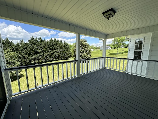 wooden terrace featuring a lawn