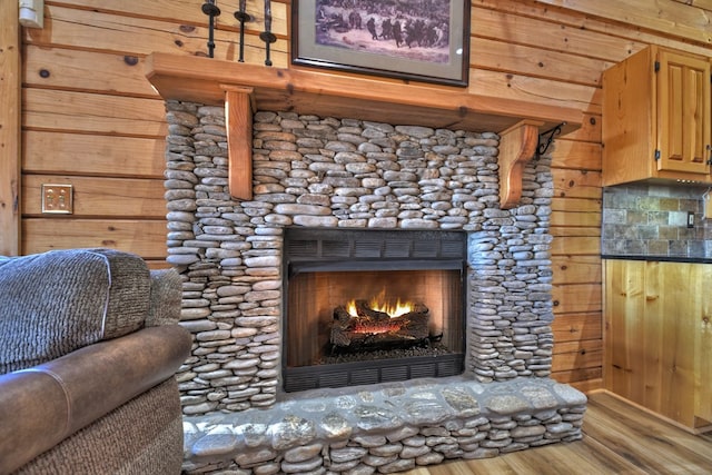 room details featuring wood walls, a fireplace, and wood-type flooring