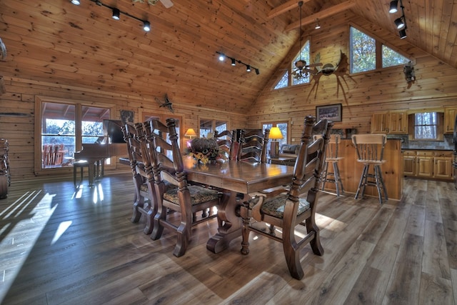 dining space featuring track lighting, high vaulted ceiling, dark hardwood / wood-style floors, and wooden ceiling