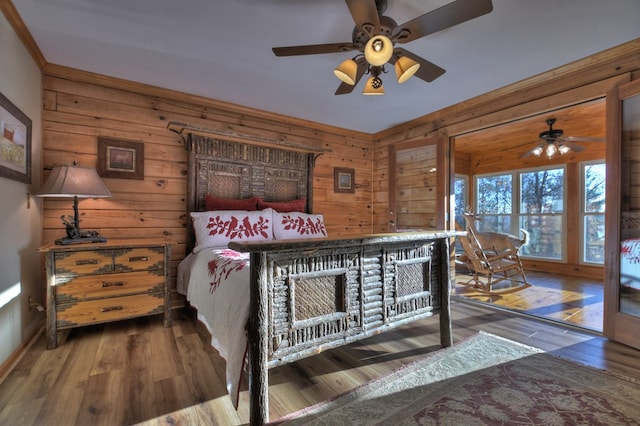 bedroom with hardwood / wood-style flooring, ceiling fan, and wood walls