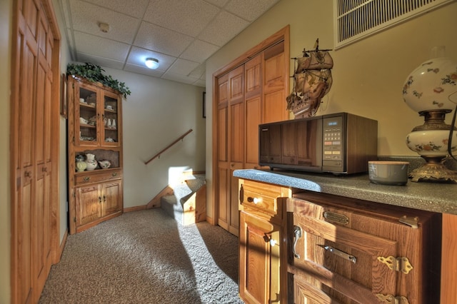 bar with a paneled ceiling and dark colored carpet