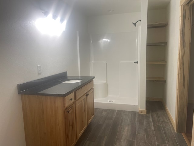 bathroom with walk in shower, vanity, and hardwood / wood-style flooring