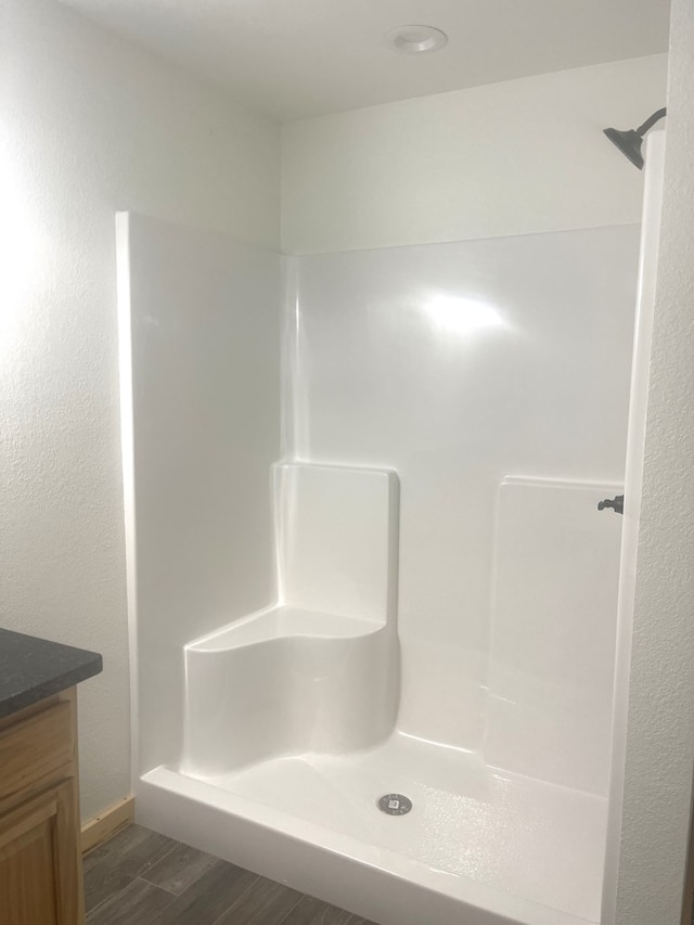 bathroom featuring hardwood / wood-style floors, vanity, and a shower