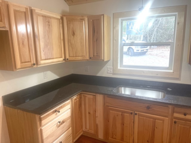 kitchen featuring pendant lighting, a wealth of natural light, and dark stone countertops