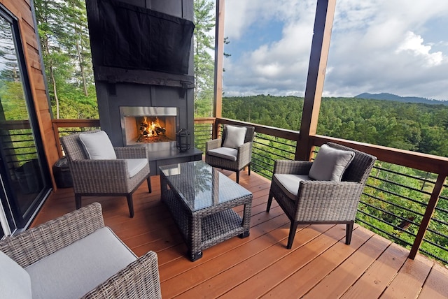 wooden deck with an outdoor fireplace