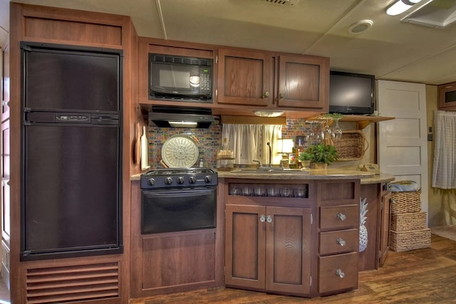 4011 Murphy Hwy, Mineral Bluff, GA 30559 - kitchen with black appliances, wood finished floors, range hood, backsplash, and brown cabinetry