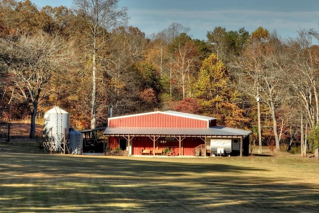 4011 Murphy Hwy, Mineral Bluff, GA 30559 - surrounding community featuring a lawn, a garage, an outdoor structure, a view of trees, and a pole building