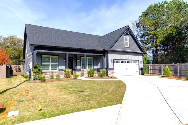 craftsman house featuring covered porch, a front yard, and a garage