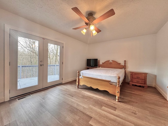 bedroom featuring access to exterior, visible vents, french doors, and light wood-style floors