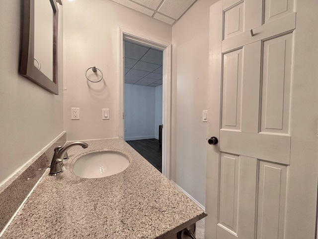 bathroom with a drop ceiling and vanity