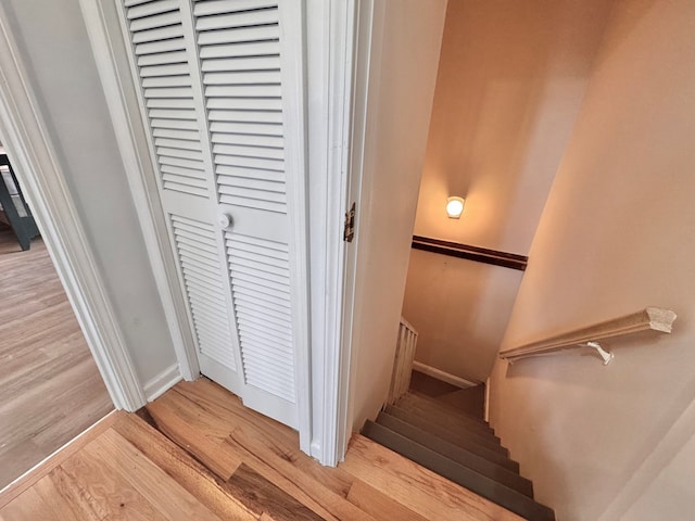 staircase featuring wood finished floors and baseboards