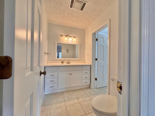 bathroom featuring vanity, visible vents, tile patterned flooring, a textured ceiling, and toilet