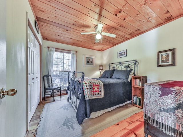 bedroom with wooden ceiling, a closet, and wood finished floors