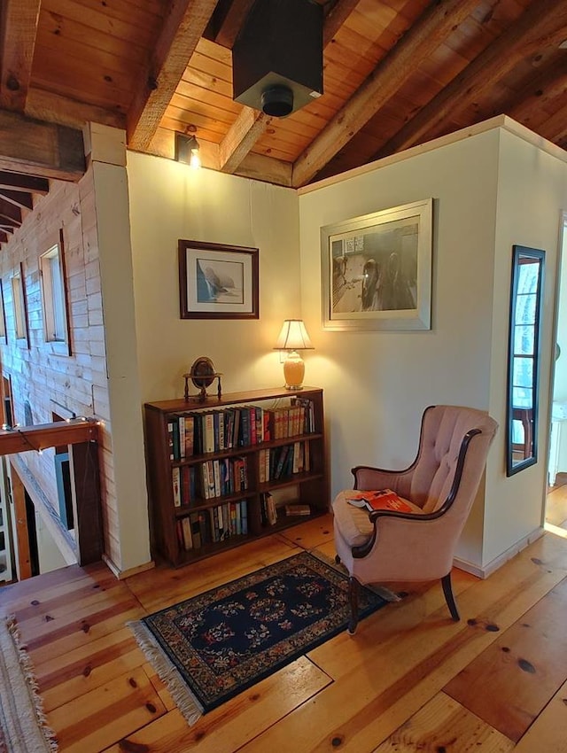 living area featuring vaulted ceiling with beams, hardwood / wood-style floors, and wooden ceiling