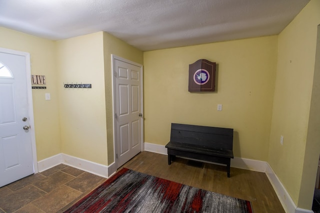 entrance foyer with baseboards, a textured ceiling, and wood finished floors