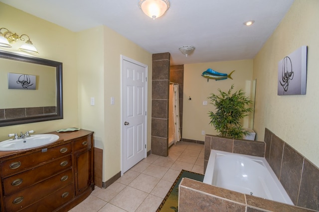 full bath with a garden tub, vanity, baseboards, and tile patterned floors