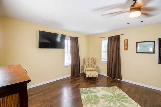 living area featuring ceiling fan, baseboards, and wood finished floors