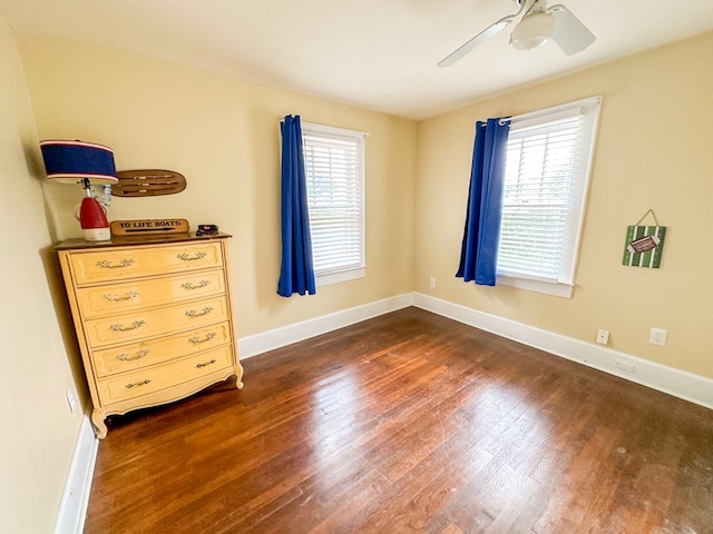 bedroom featuring dark wood-type flooring, multiple windows, and baseboards