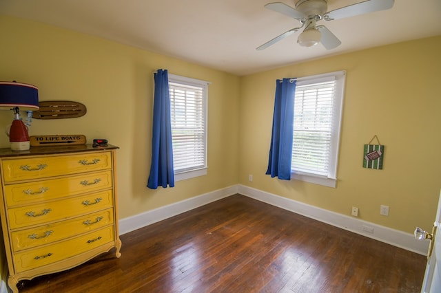 bedroom with dark wood-style flooring, a ceiling fan, and baseboards