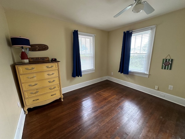 bedroom featuring a ceiling fan, multiple windows, baseboards, and dark wood-style flooring