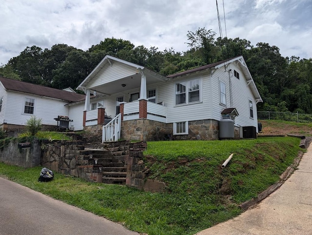 bungalow-style home with stairs, fence, and central air condition unit