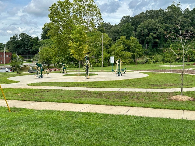 view of property's community featuring playground community and a yard