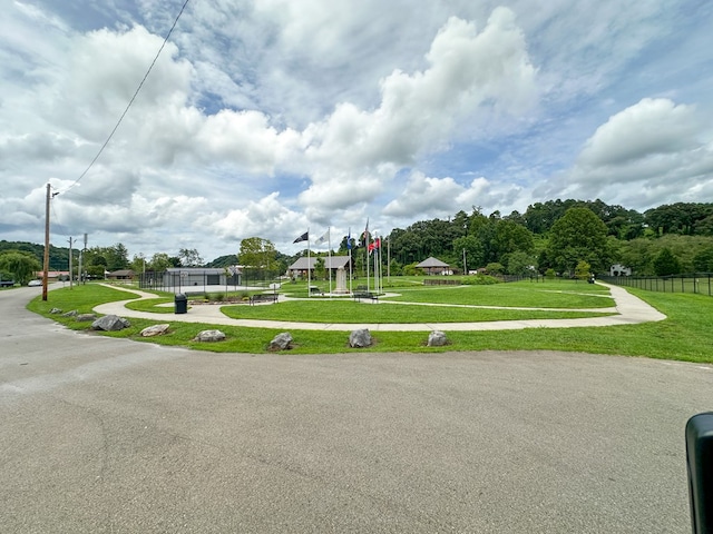 view of community featuring a yard and fence