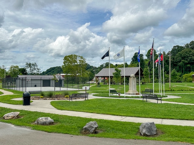 view of community featuring a yard and fence